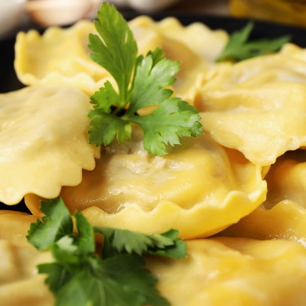 Close-up of Milan's ravioli pasta with fresh parsley garnish.