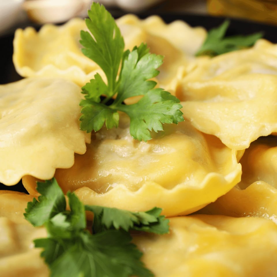 Close-up of Milan's Pizza ravioli, garnished with fresh parsley, ready to be served.